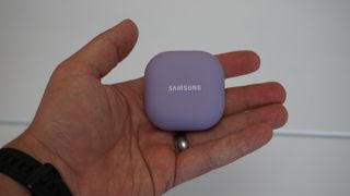 El estuche de carga de los Samsung Galaxy Buds 2 Pro en la mano de alguien, sobre un fondo blanco