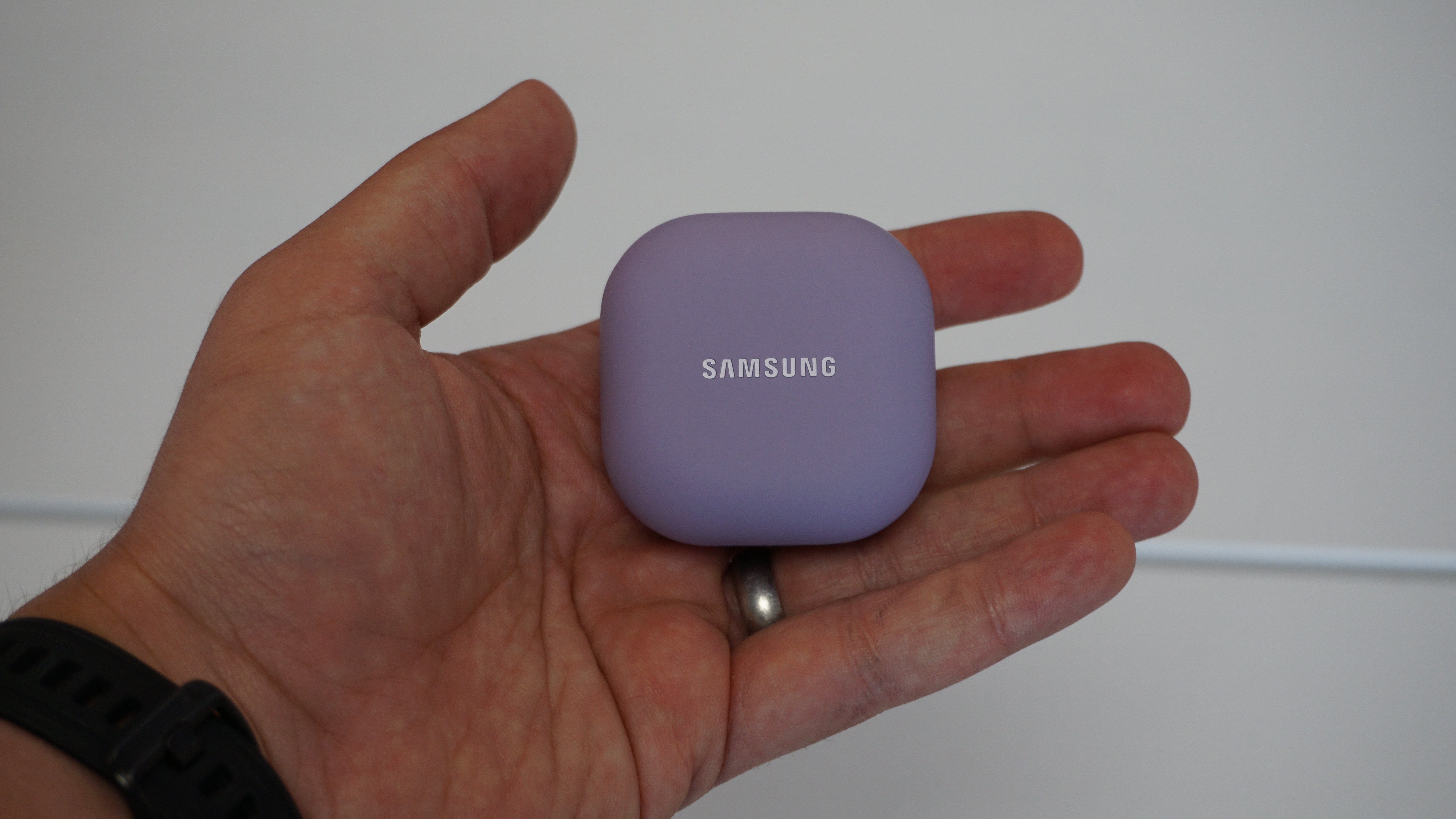 Funda Samsung Galaxy Buds 2 Pro sostenida en la mano sobre fondo blanco