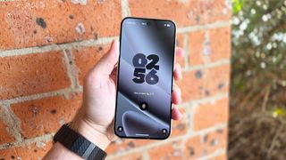 In-hand photo of the Google Pixel 10 Pro XL in front of brick wall