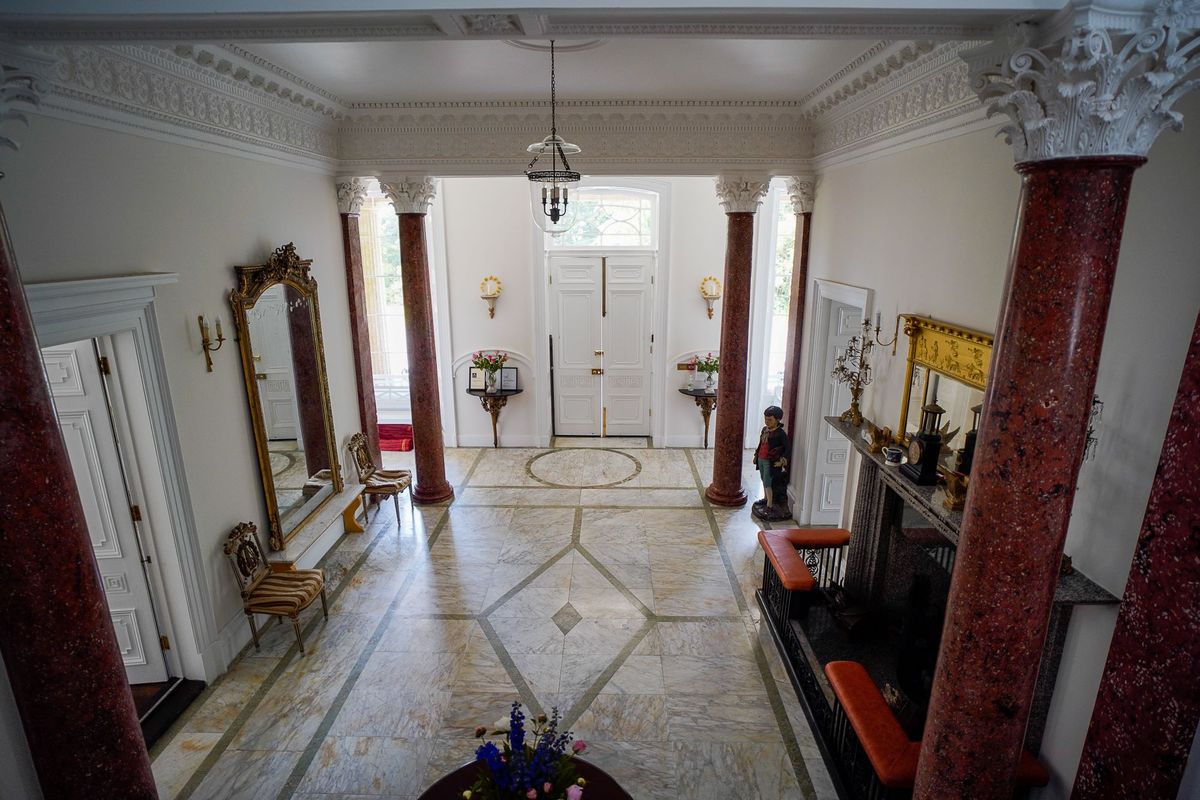 A view of the hallway with marble flooring and large red marble columns