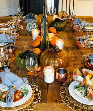 A thanksgiving-themed dining table with various colored glass pumpkin decorations