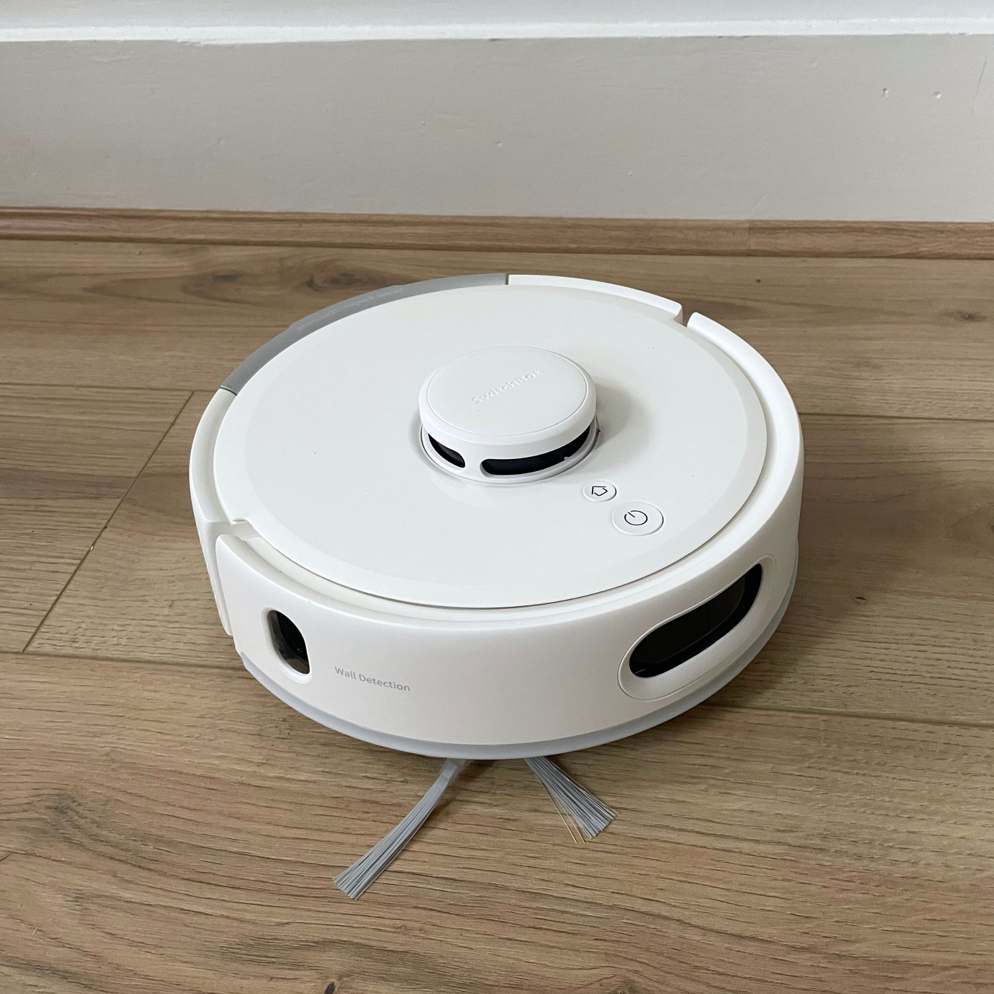 SwitchBot K11+ Robot Vacuum Cleaner with Mop bot sitting on wood-effect flooring