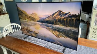 De Samsung QE55Q60B-tv op een tv met een afbeelding van een gebergte erop.