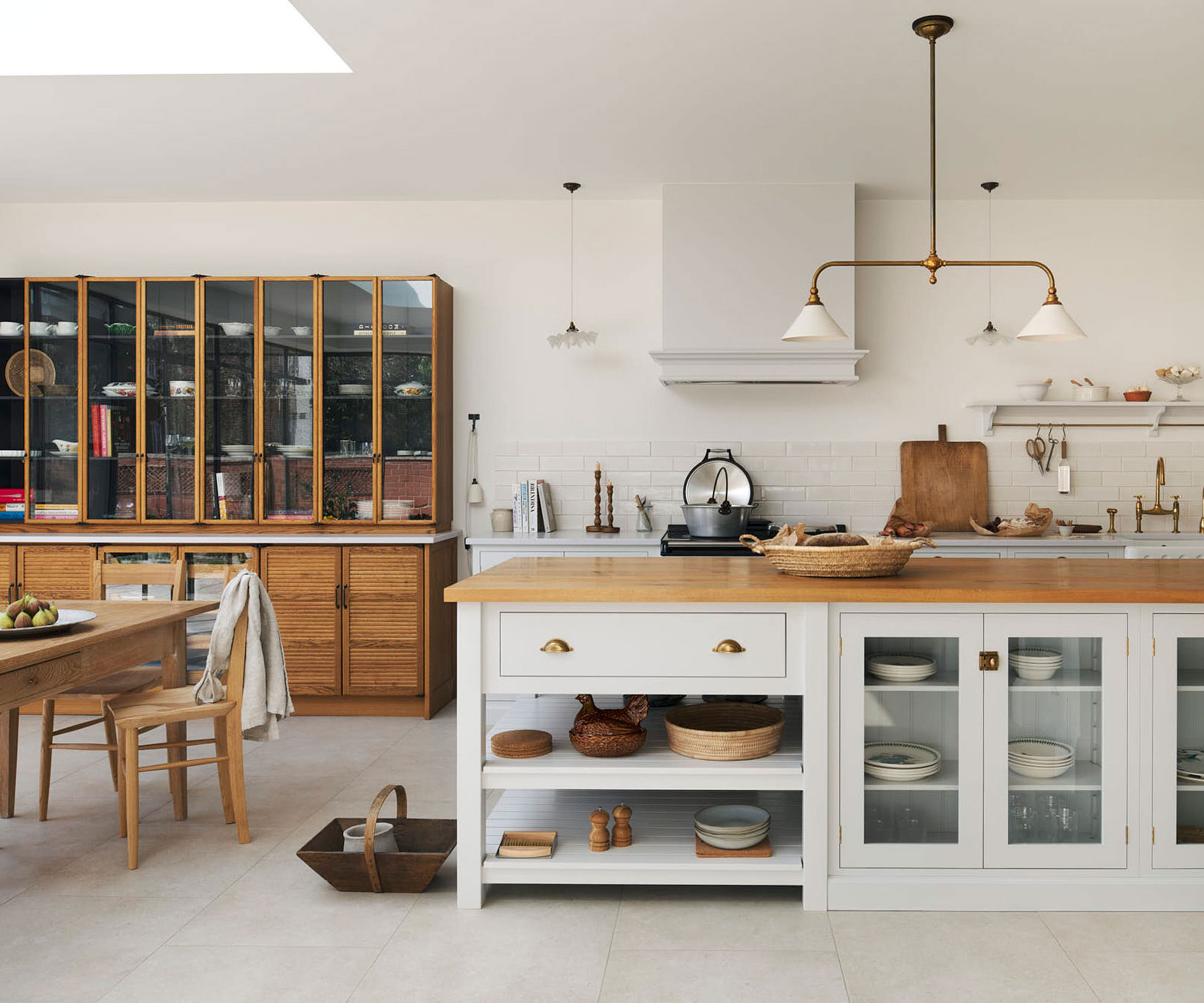 white kitchen diner with glass fronted units and wooden worktops