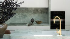 modern kitchen with pale green counters and white cabinets