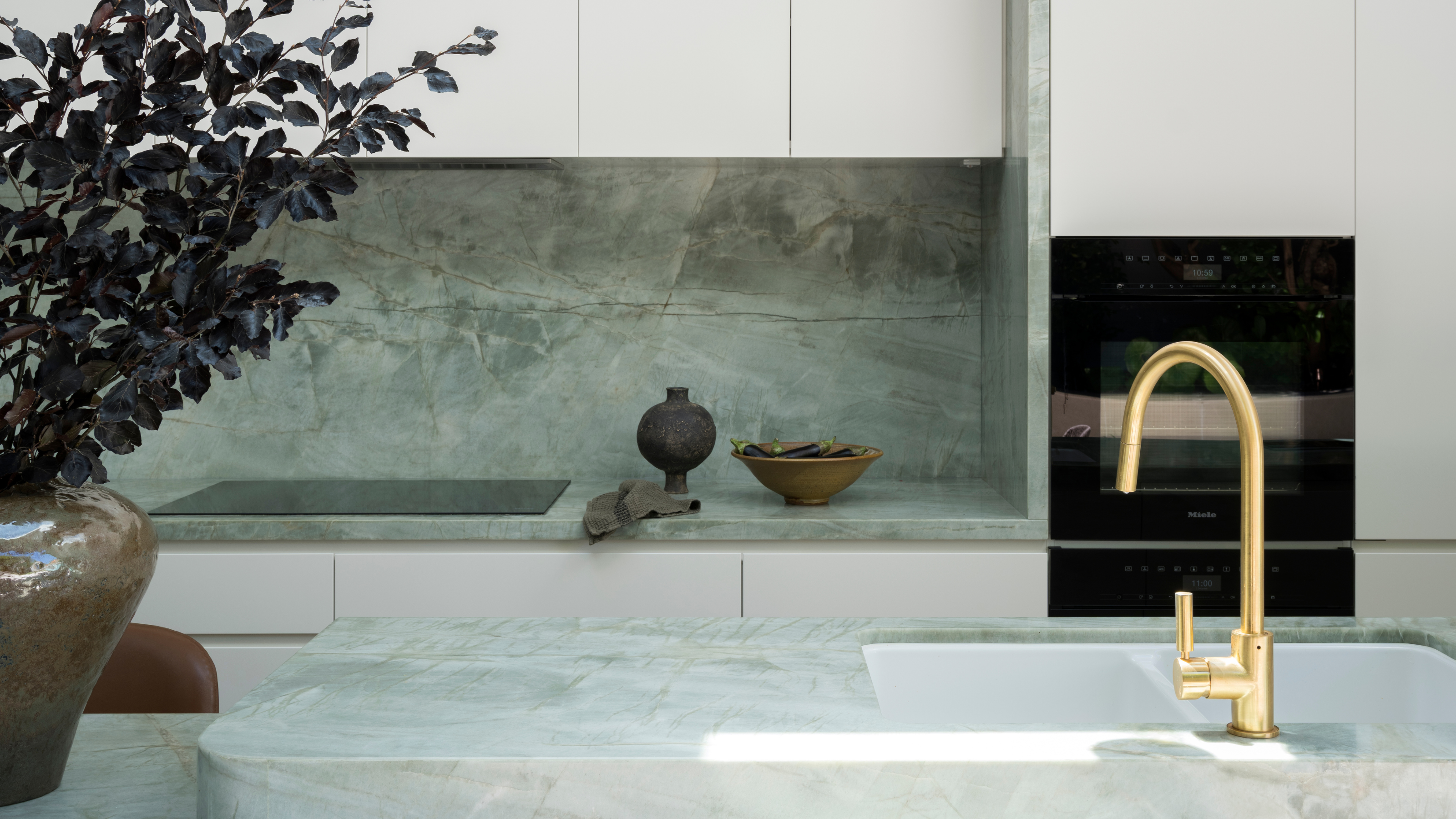 modern kitchen with pale green counters and white cabinets