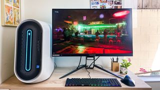 Alienware Aurora R13 sitting on desk connected to Acer Predator monitor, with Cyberpunk 2077 playing onscreen