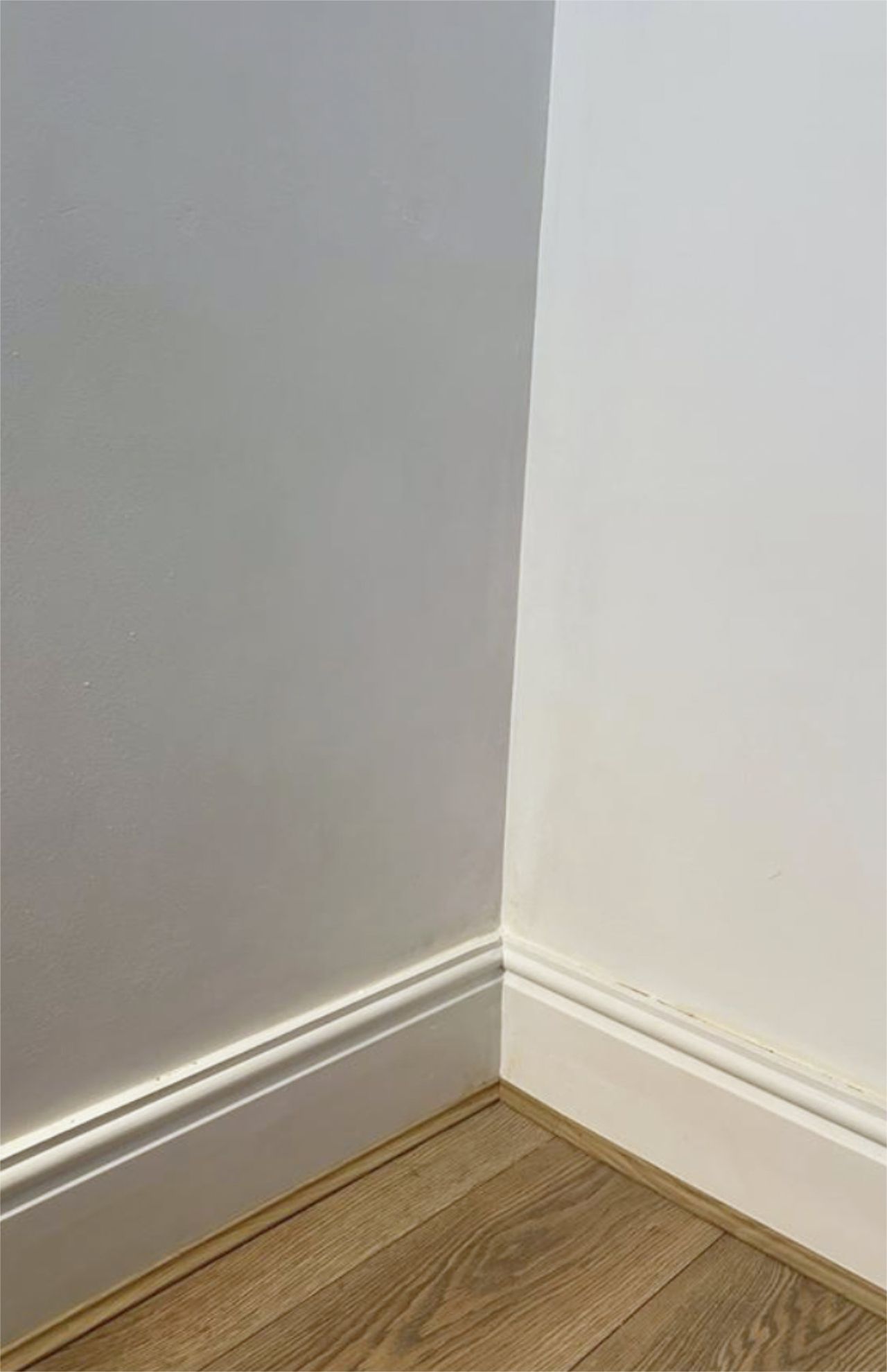 A clean bedroom wall with laminate flooring