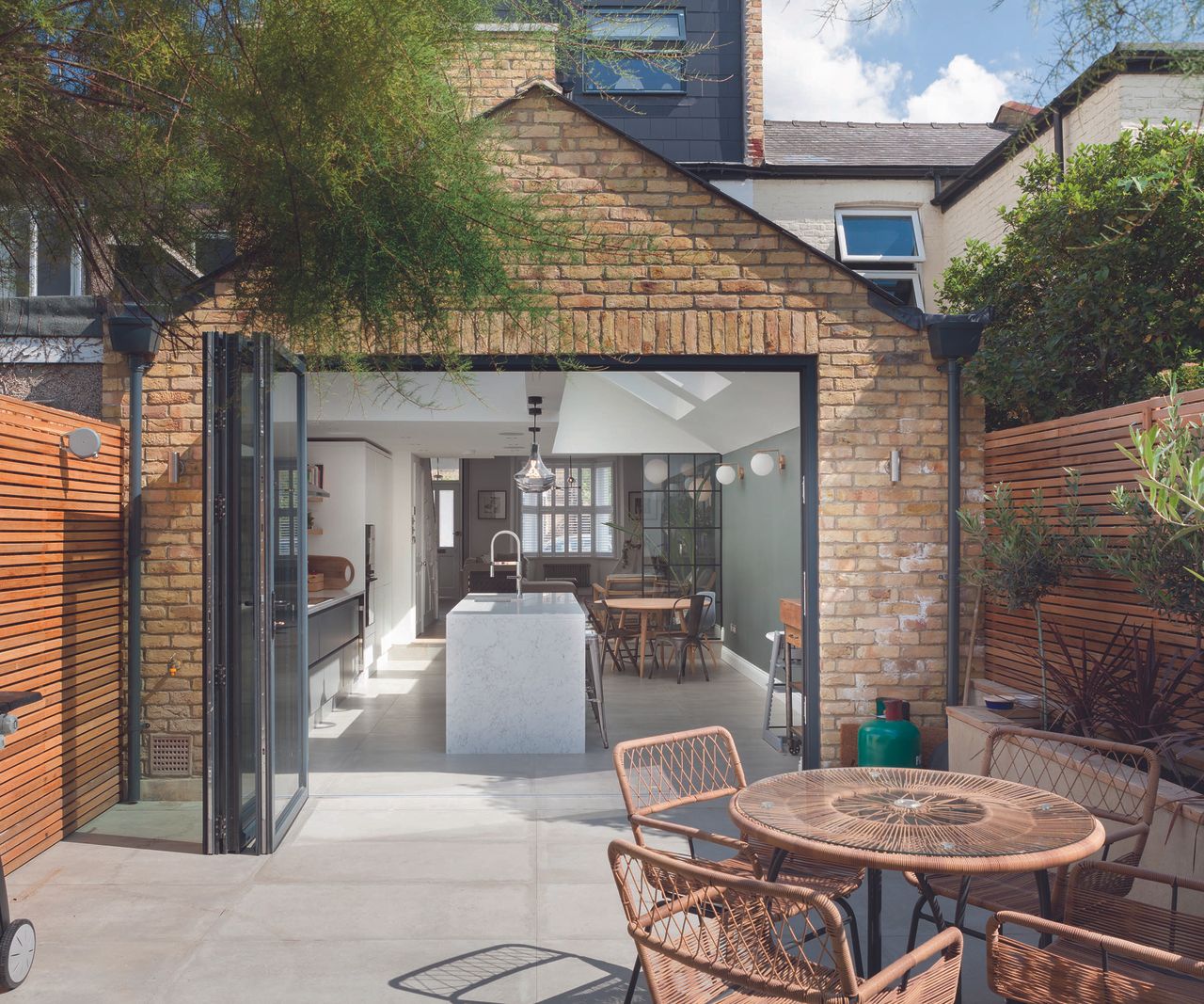 Pitched roof extension with bifold doors with seamless flooring connection to the patio