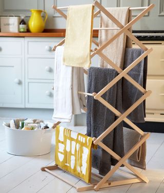 room with wooden laundry drying rack towel and white floor