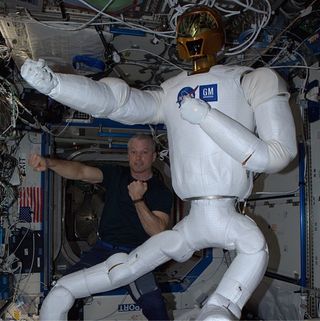 NASA astronaut Steve Swanson poses with the robot Robonaut 2 on the International Space Station after completing an upgrade that gave the robot legs.