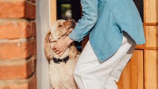 Woman greeting dog at front door