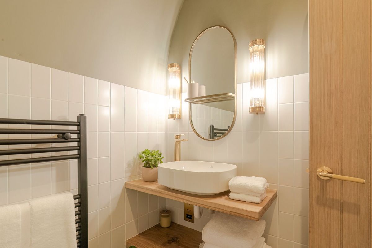 A neutral toned bathroom with sink and mirror in the caravan