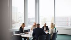 Boardroom meeting with executives discussing business issues, including CTO, CISO, CIO, and CEO.