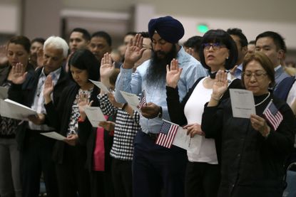 Immigrants swear the oath to become new U.S. citizens at a naturalization ceremony in Los Angeles.