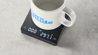 a black square coffee scale by Maestri House with a timer and a rechargeable battery