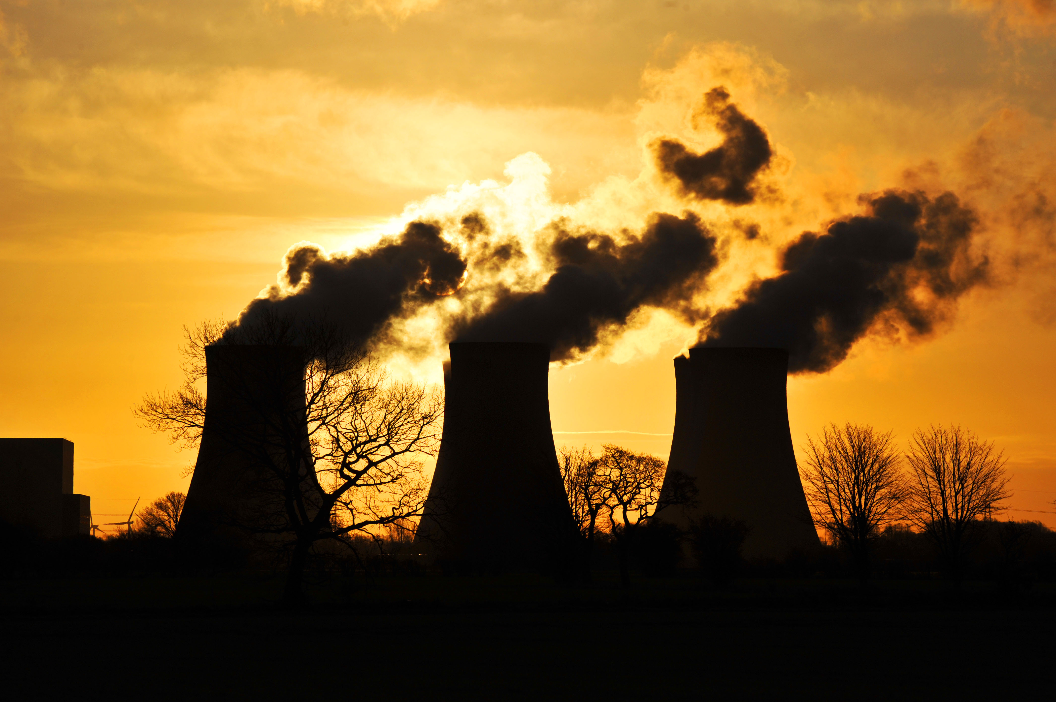 Cooling towers, silhouetted against the orange rising sun