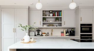 Light gray kitchen with kitchen storage built to the ceiling height along one wall