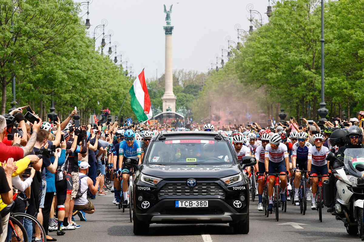 Spectators cheer as riders gather behind the races director car prior to the start of the first stage of the Giro dItalia 2022 cycling race 195 kilometers between Budapest and Visegrad Hungary on May 6 2022 Photo by Luca Bettini AFP Photo by LUCA BETTINIAFP via Getty Images