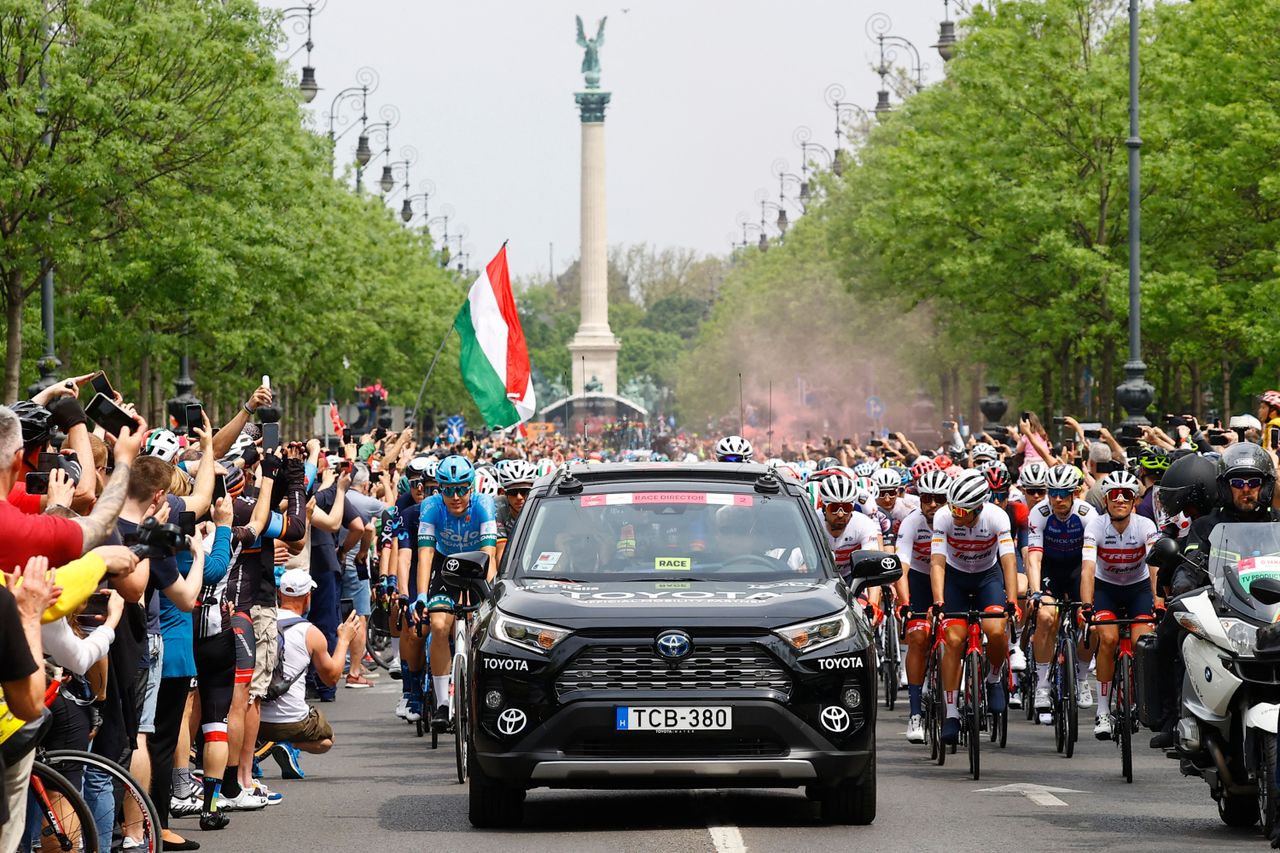Spectators cheer as riders gather behind the races director car prior to the start of the first stage of the Giro dItalia 2022 cycling race 195 kilometers between Budapest and Visegrad Hungary on May 6 2022 Photo by Luca Bettini AFP Photo by LUCA BETTINIAFP via Getty Images