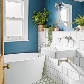 Blue bathroom with white tiles and bathtub