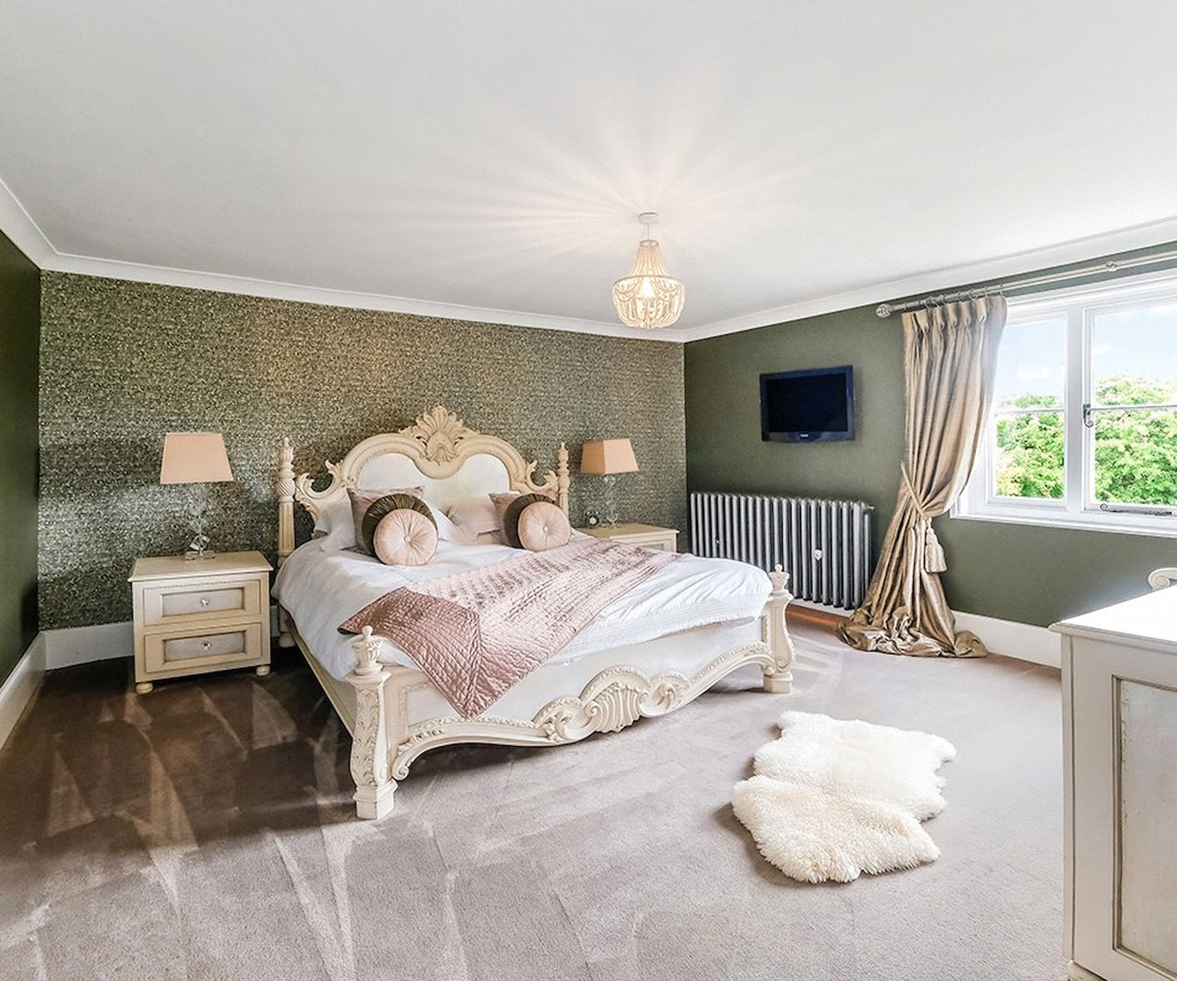 A master bedroom with large windows and a Victorian style bed frame