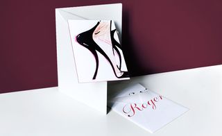 envelope swathed with a red foil logo, graced with an illustration of a stiletto heel