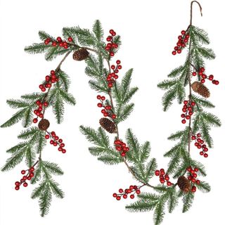 A green pine leaf garland with red berries and pine cones