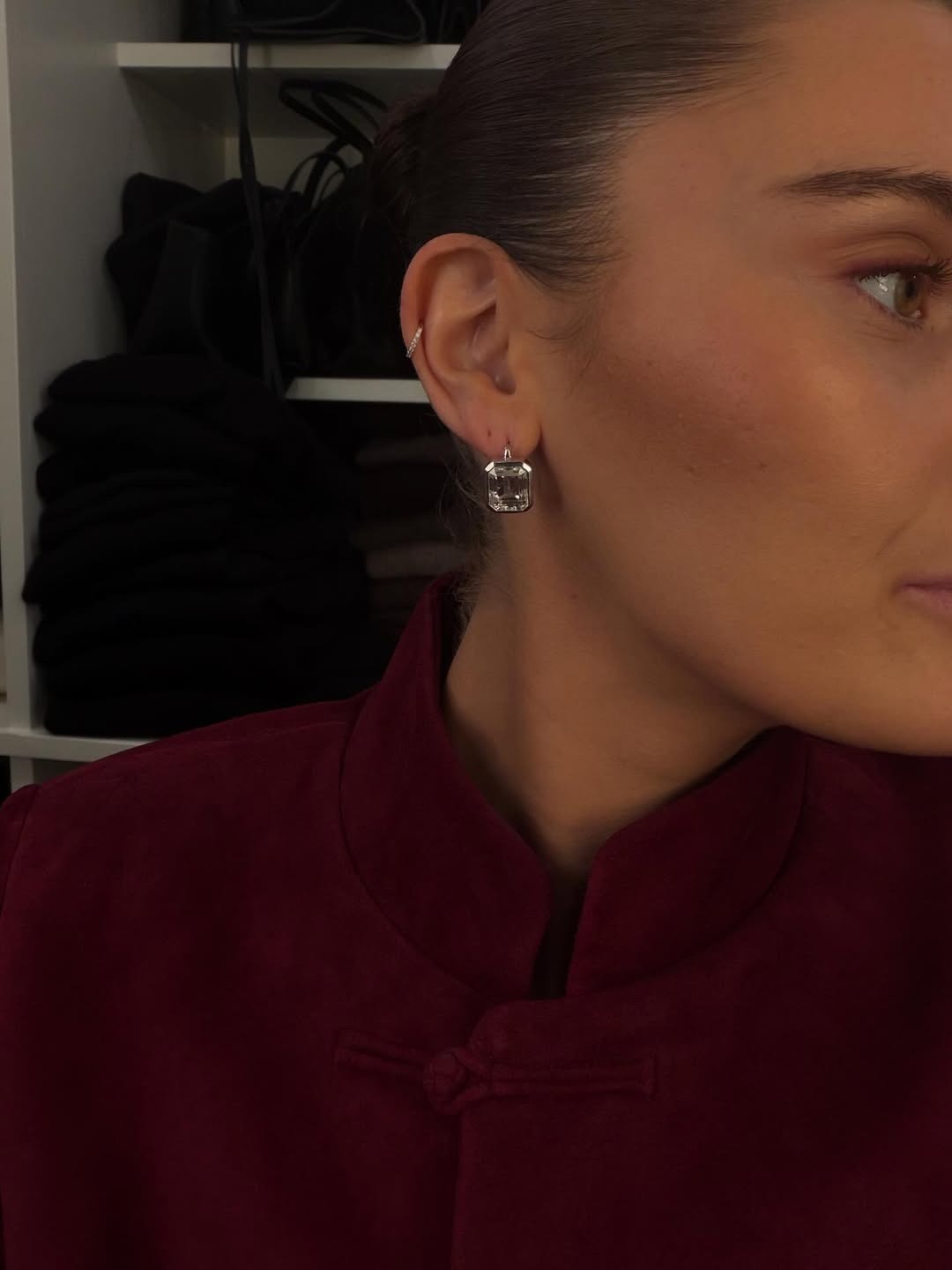 Woman wearing diamond bezel earrings.