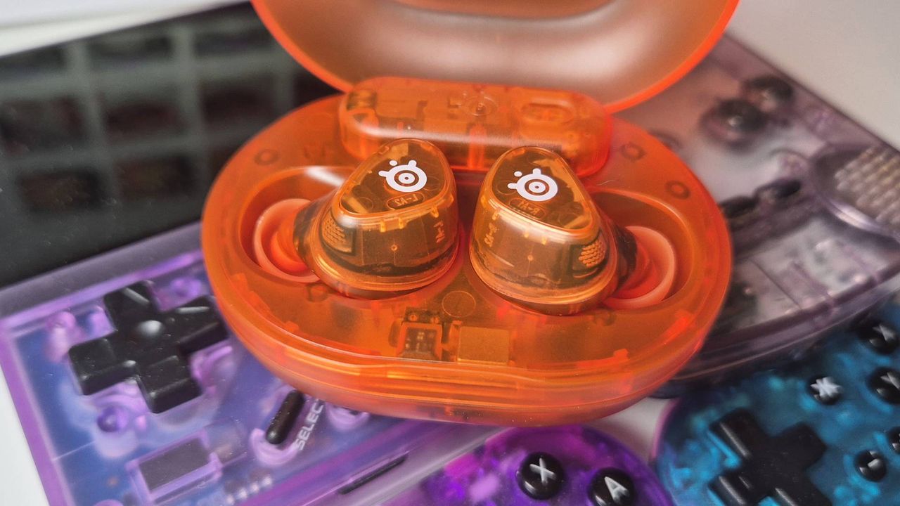 Photo of the Glorange Arctis GameBuds by SteelSeries taken by writer Rosalie Newcombe, sitting on top of the Atomic Purple Miyoo Mini Plus and Game Boy Color.