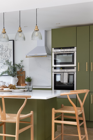 green kitchen with island and oven