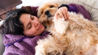 Woman cuddling her dog