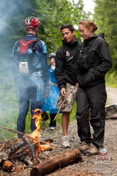 People warm up around the campfire on a wet day