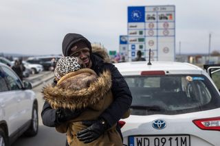 Refugees arriving from Ukraine embrace at the border crossing in Medyka, eastern Poland on March 1, 2022. - Overall, more than half a million people have fled Ukraine since its Soviet-era master Moscow launched a full-scale invasion on February 24, with more than half fleeing into neighbouring EU and NATO member Poland, the United Nations said on February 28, 2022.