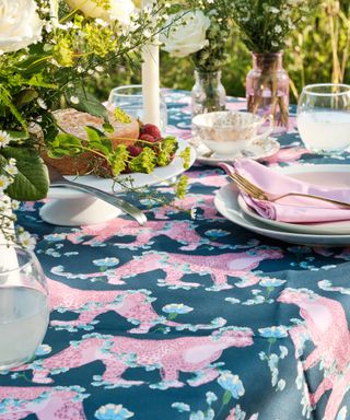 patterned tablecloth on garden table setting with flowers