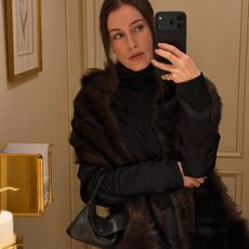 Annabel wears a fur coat and the row sally bag.