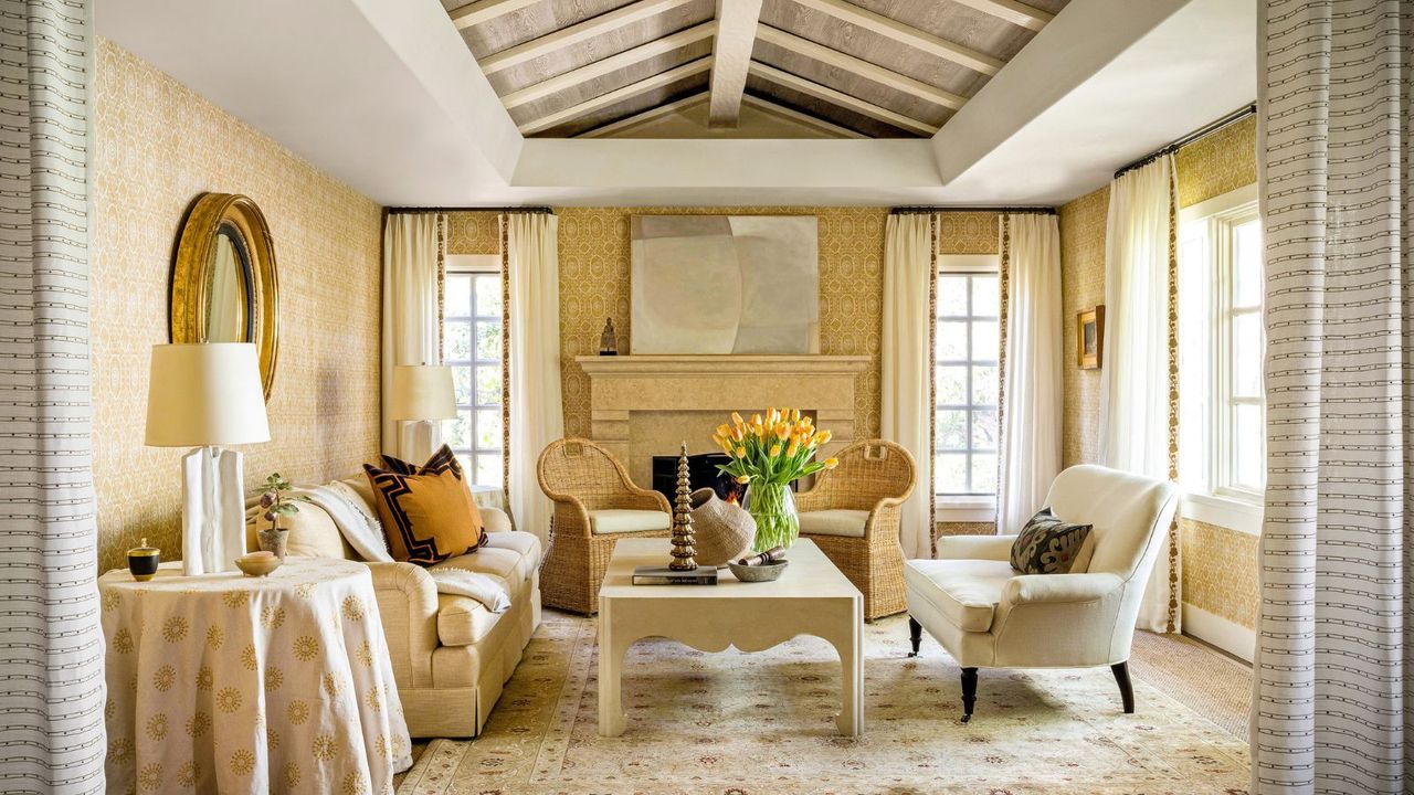 yellow living room with textured wallcovering and vaulted ceiling, white sofas and rattan chairs