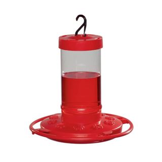 A red hummingbird feeder with a hook on top, a tube with red liquid in the middle, and a circular base with flowers on it