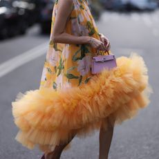 Leonie Hanne seen wearing a yellow tulle flower dress by Carolina Herrera, pink glitter heels and a Hermes mini kelly before the Carolina Herrera show on February 13, 2023 in New York City