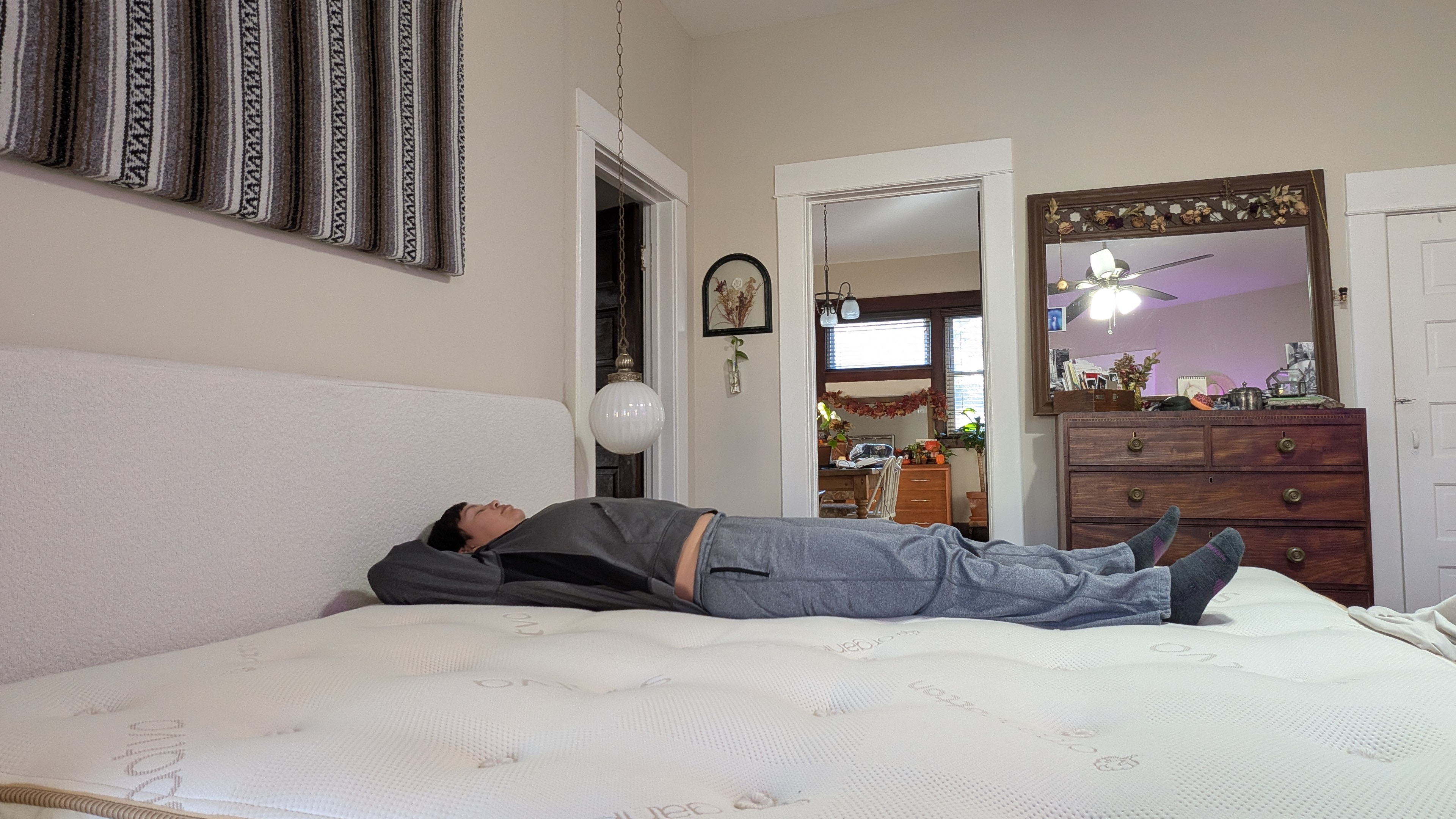 Mattress tester Alex laying on her back the Saatva Latex Hybrid Mattress to show its level of comfort and support in that position