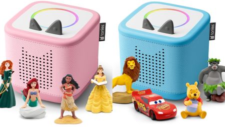 A pink Toniebox 2 with Merida, Ariel, Moana, and Belle. It's next to a blue Toniebox 2 with Simba, Lightning McQueen, Winnie The Pooh, and Baloo. 