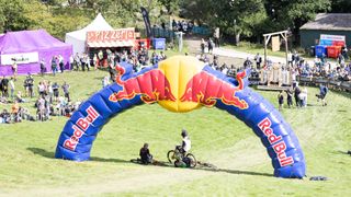 Riders enjoying the sun under the Red Bull arch at 2022 Hardline