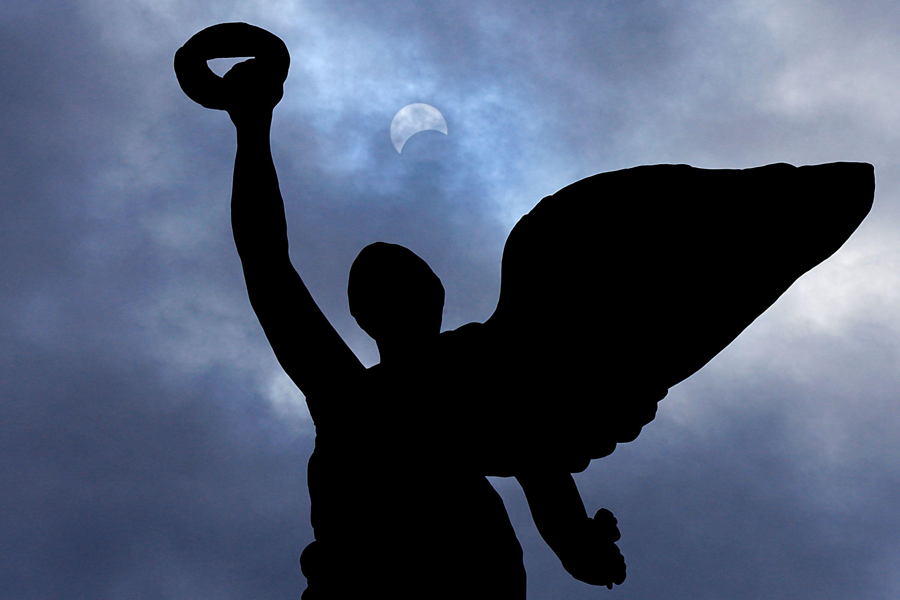 토론토 프린스 게이트 위의 천사 프레임에서 개기 일식이 진행되는 동안 달이 태양 앞으로 나아갑니다.