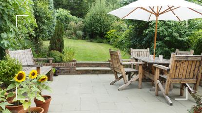 Garden with patio area with wooden table and chairs set to support an expert guide on how to clean patio slabs