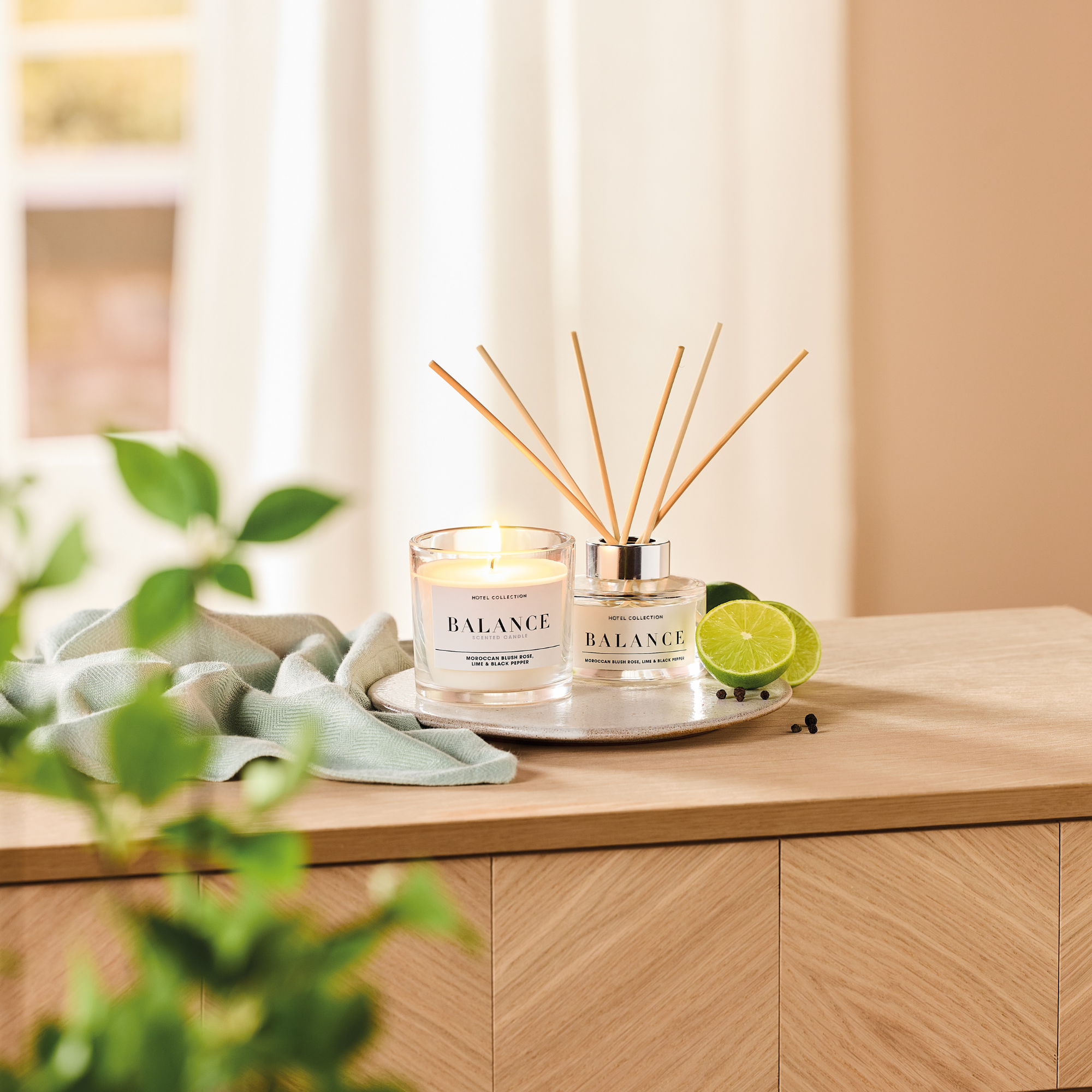 Aldi Balance candle and reed diffuser on wooden sideboard.