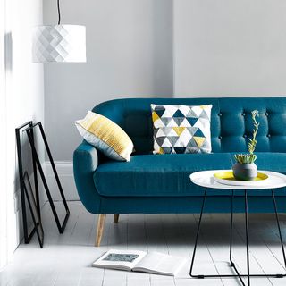 room with denim blue sofa and white wall
