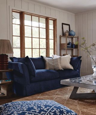 white panelled living room with navy couch