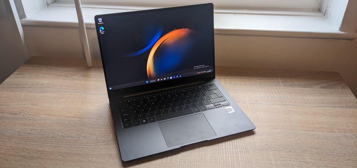 The Samsung Galaxy Book3 Pro 14-inch laptop pictured atop a wooden desk.