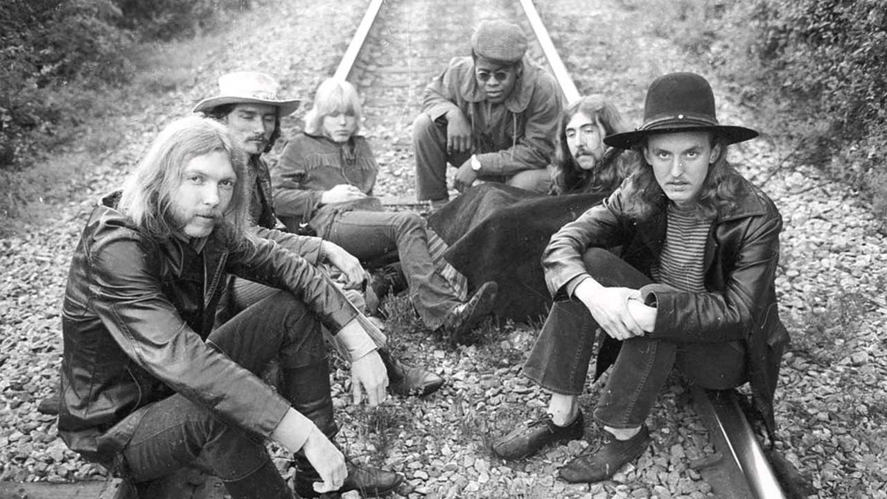 The Allman Brothers Band seated on a railway line