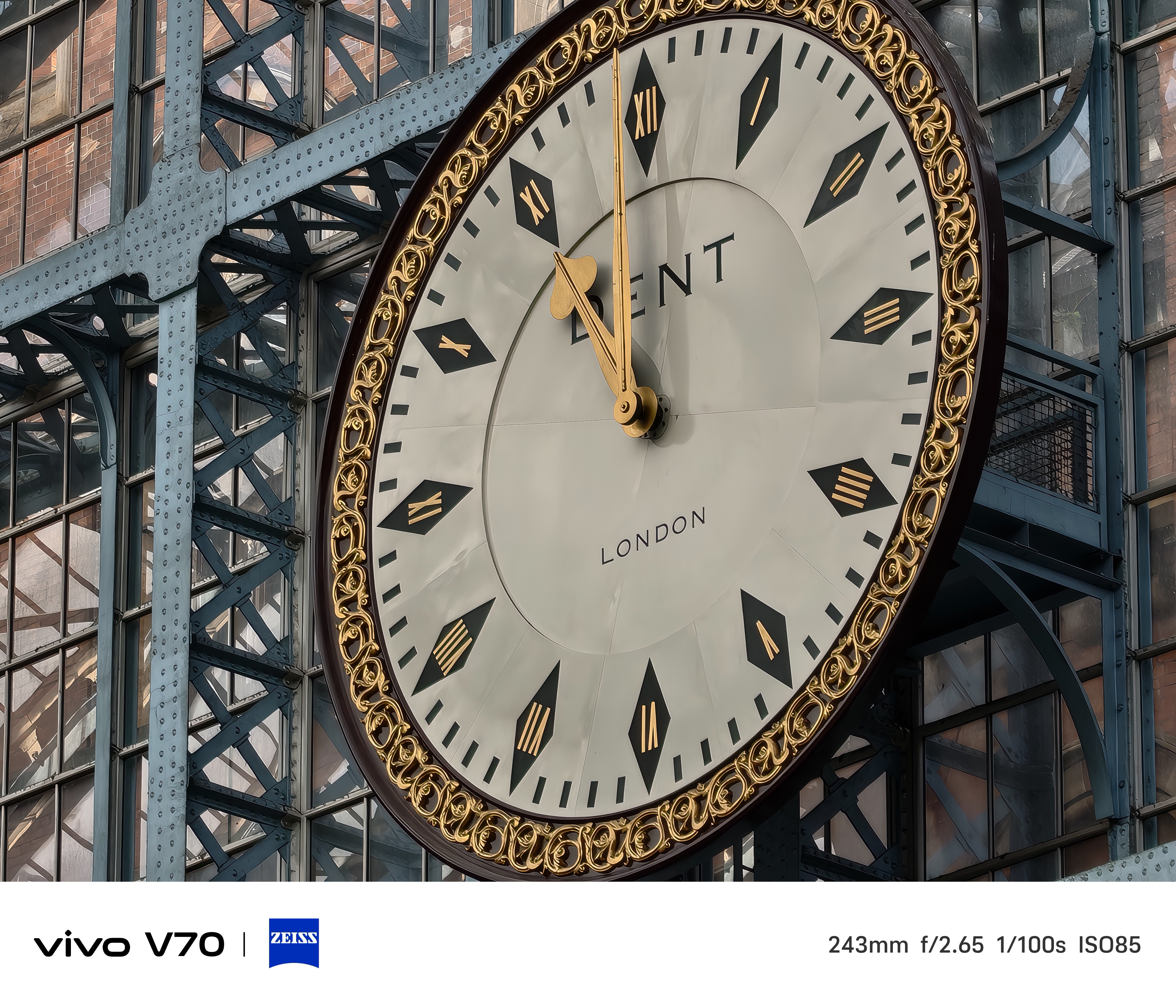 Tight close-up of the ornate London station clock with gold trim and Roman numerals.